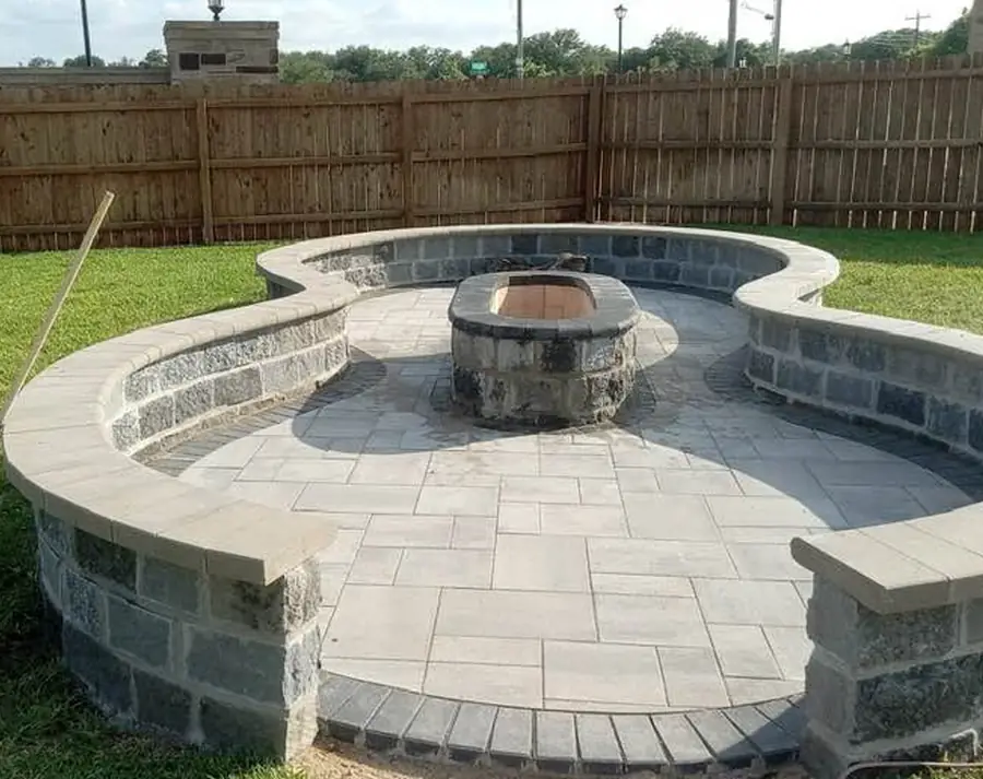 Curved seating wall and stone fire pit on a paver patio