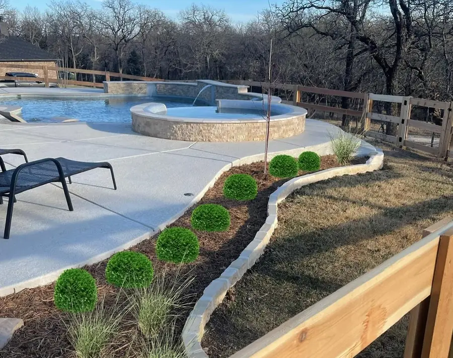Pool deck with a stone border and fresh landscaping