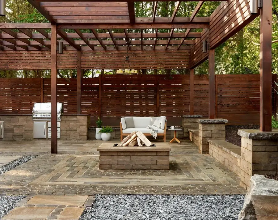 Cedar pergola with a fire pit and outdoor kitchen on a paver patio