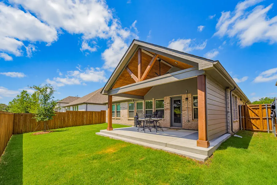 Gabled patio cover with a stained wood ceiling and cedar posts over a raised concrete slab